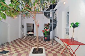 a room with a table and a tree on a checkered floor at Neoclassical House with Unique Athenian Yard (nearby metro station) in Athens