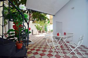 a patio with a table and chairs and plants at Neoclassical House with Unique Athenian Yard (nearby metro station) in Athens