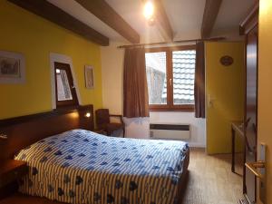 a hotel room with a bed and a window at Au Cep de Vigne in Riquewihr