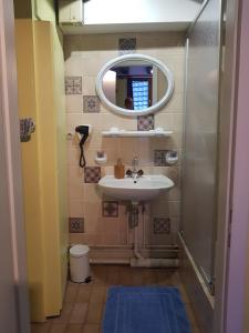 a bathroom with a sink and a mirror at Au Cep de Vigne in Riquewihr