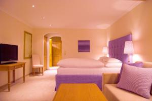 レッヒにあるホテル アラベルの大きなベッドとソファが備わるホテルルームです。