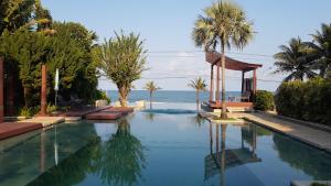 a swimming pool with a gazebo and the ocean at Pranaluxe Pool Villa Holiday Home in Pran Buri
