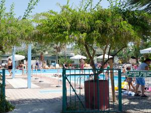 a group of people standing around a swimming pool at Kamemi Village & Camping in Ribera