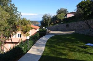 un jardín con una pared de piedra y una pasarela en Apts. Serena by SolturElba, en Capoliveri