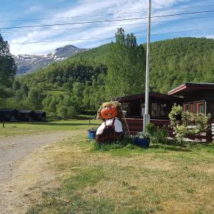 Ein großer Teddybär sitzt vor einem Haus in der Unterkunft Steinklepp Camping in Övre Kvamme + 11 Fotos