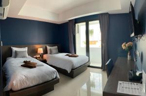 2 camas en una habitación con paredes azules en The Seens Hotel, en Krabi