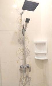 a shower with a solar panel on a wall at Fams Homestay by FH Stay in Yogyakarta