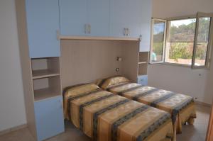 a bedroom with two beds and a window at Apts. Serena by SolturElba in Capoliveri