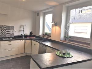 a kitchen with white cabinets and a sink and windows at Chambre d'hôte-abc in Reims +21 photos
