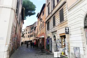 an alley with people walking down a street with buildings at Luxury Trastevere in Rome
