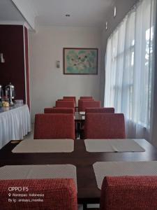 uma sala de conferências com uma mesa e cadeiras vermelhas em Hotel Monika em Rantepao