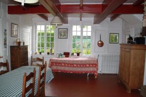 a room with a table and two beds in it at Chambres d'hôtes Manoir du Buquet in Honfleur