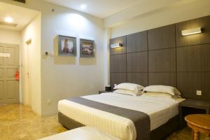 a bedroom with a large bed and a table at Dreamtel Jakarta in Jakarta