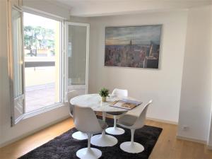 a dining room with a table and chairs and a window at chambre d'hôte-abc in Reims