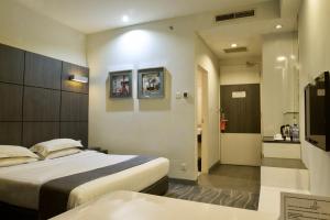 a hotel room with two beds and a bathroom at Dreamtel Jakarta in Jakarta