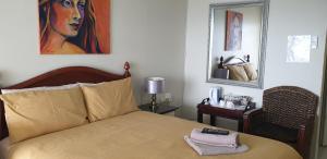 um quarto com uma cama e um quadro na parede em The Homestead Margate - South Africa em Margate