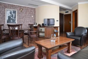 a living room with leather furniture and a television at Hotel Hill in Jagodina