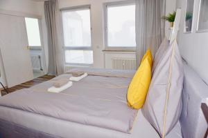 a bedroom with a large bed with yellow pillows at MH Apartment in Königsbrunn