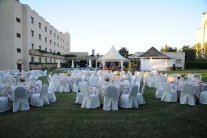 a group of white tables and chairs in a field at Hotel Vegas Altas in Don Benito