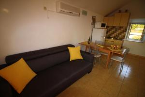 a living room with a black couch and yellow pillows at Apartmani Šolo in Sumartin