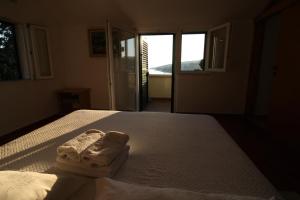 a bedroom with a bed with two towels on it at Apartmani Šolo in Sumartin