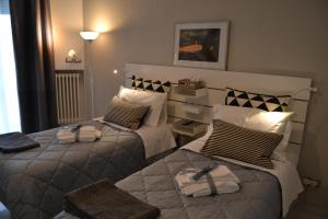 - une chambre avec 2 lits et des serviettes dans l'établissement Il profumo dei Sassi Holiday Home, à Matera