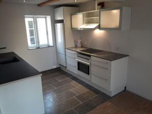 a kitchen with white cabinets and a counter top at Elmealle 6 in Skjern