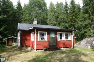 a small red cabin in the middle of a field at Insel Korsnäsudden in Hagfors