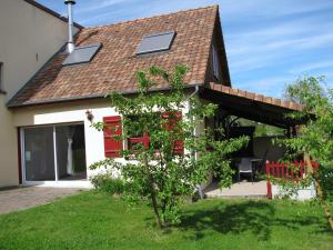 ein Haus mit roten Fenstern und einem Baum im Hof in der Unterkunft La Bergerie du festel in Saint-Riquier