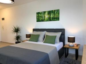 een slaapkamer met een groot bed met groene kussens bij Apartmani Učka in Opatija