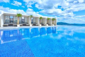 una piscina con palmeras y un edificio en Ala Mahaina Condo Hotel en Motobu