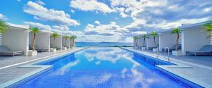 una piscina en un hotel con vistas al océano en Ala Mahaina Condo Hotel, en Motobu