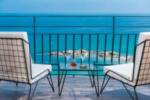two chairs and a glass table on a balcony at Hotel Santa Marta in Lloret de Mar
