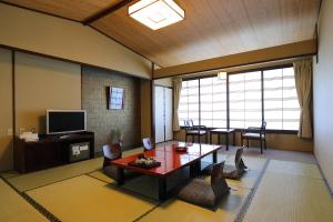a living room with a table and a tv at Arima Gyoen in Kobe