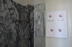 baño con ducha y toallas en la pared en Entre Vinhas & Mar, en Óbidos
