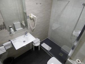 
a bathroom with a toilet, sink, and shower stall at Cuatro Naciones in Barcelona
