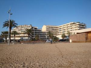 a person standing on a beach with a building in the background at Acapulco Frejus Plage in Fréjus