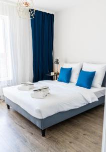- une chambre avec un grand lit et des oreillers bleus dans l'établissement Blue Raven Downtown Apartments, à Gdańsk
