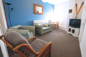 a living room with two chairs and a tv at The Crows Nest Holiday Home in Burry Port