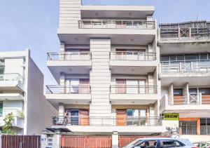 a tall white building with cars parked in front of it at Skylink Suites Bed & Breakfast in New Delhi