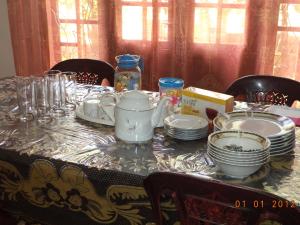 una mesa con platos y tazas y platos en ella en Mount View Family Rest & Cottage en Haputale