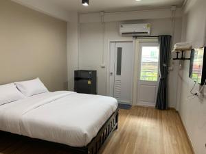 
a bedroom with a white bed and white walls at 9TY hotel (ninety hotel) in Bangkok
