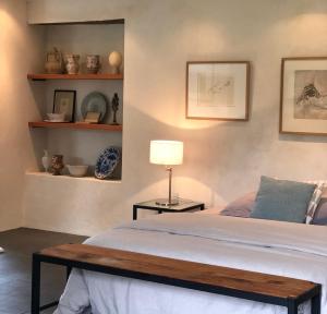 una camera con letto, tavolo e scaffali di Les Rochers a Cerisy-la-Forêt