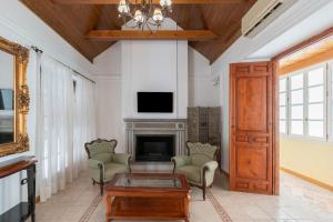 馬拉加的住宿－CASA MIRAFLORES，客厅设有壁炉和电视。
