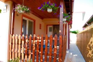 a wooden fence in front of a house with flowers at Casa cu Castan in Eforie Nord