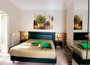una camera con 2 letti con cuscini verdi di Abatellis Luxury a Palermo