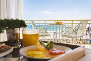 a table with a plate of fruit and a glass of beer at Hotel Almirante in Alicante