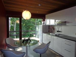 a kitchen with a glass table and some chairs at Green Hill Apartment Overijse in Overijse