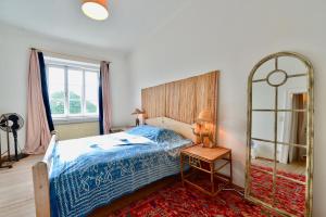 1 dormitorio con cama azul y espejo en Vienna's Most Charming Home, en Viena