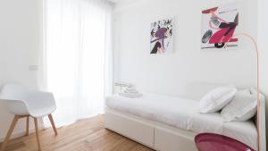 a white bedroom with a bed and a chair at Italianway - De Cristoforis 12 Flat in Milan